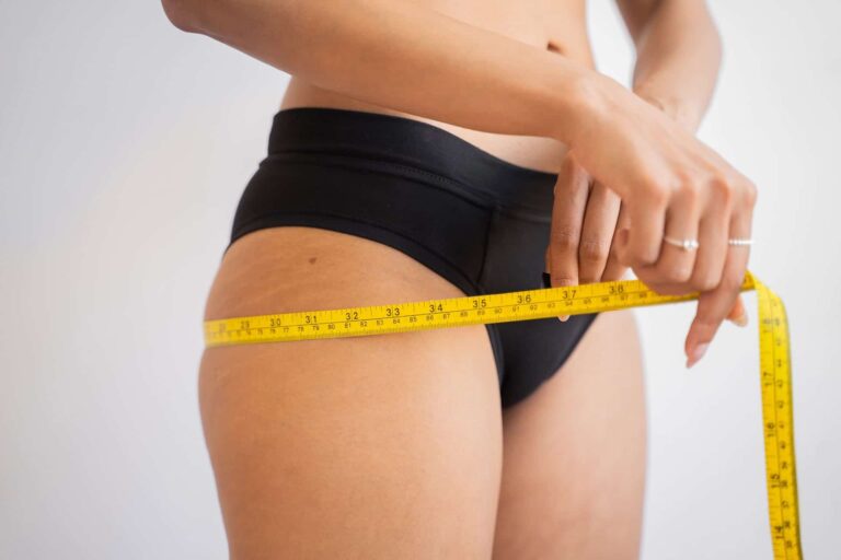 Woman measuring her body with a tape measure. Body health check.